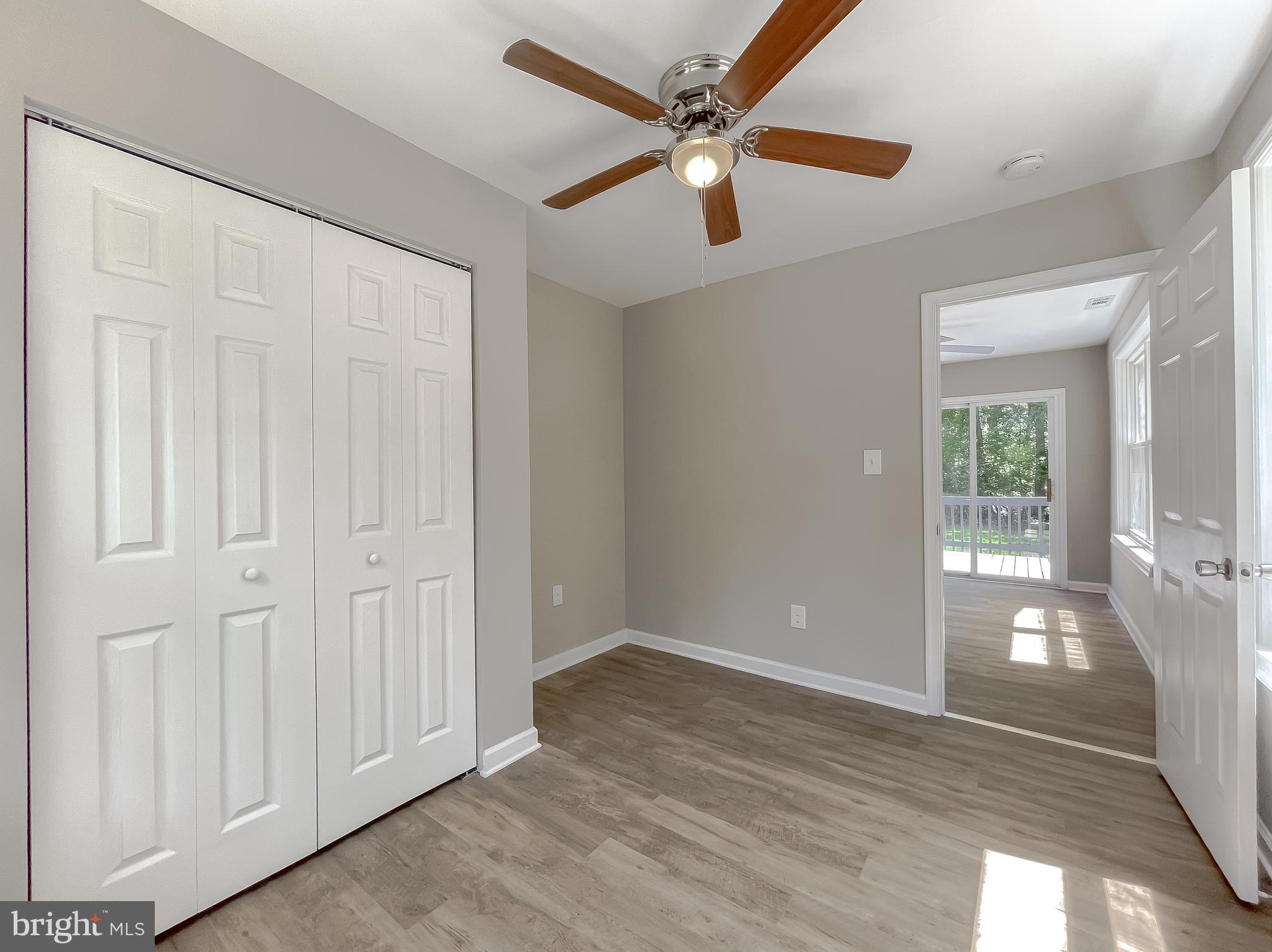 1607 Beech Road St. Leonard, MD 20685 - Photo 22 of 33 an empty room with wooden floor fan and windows