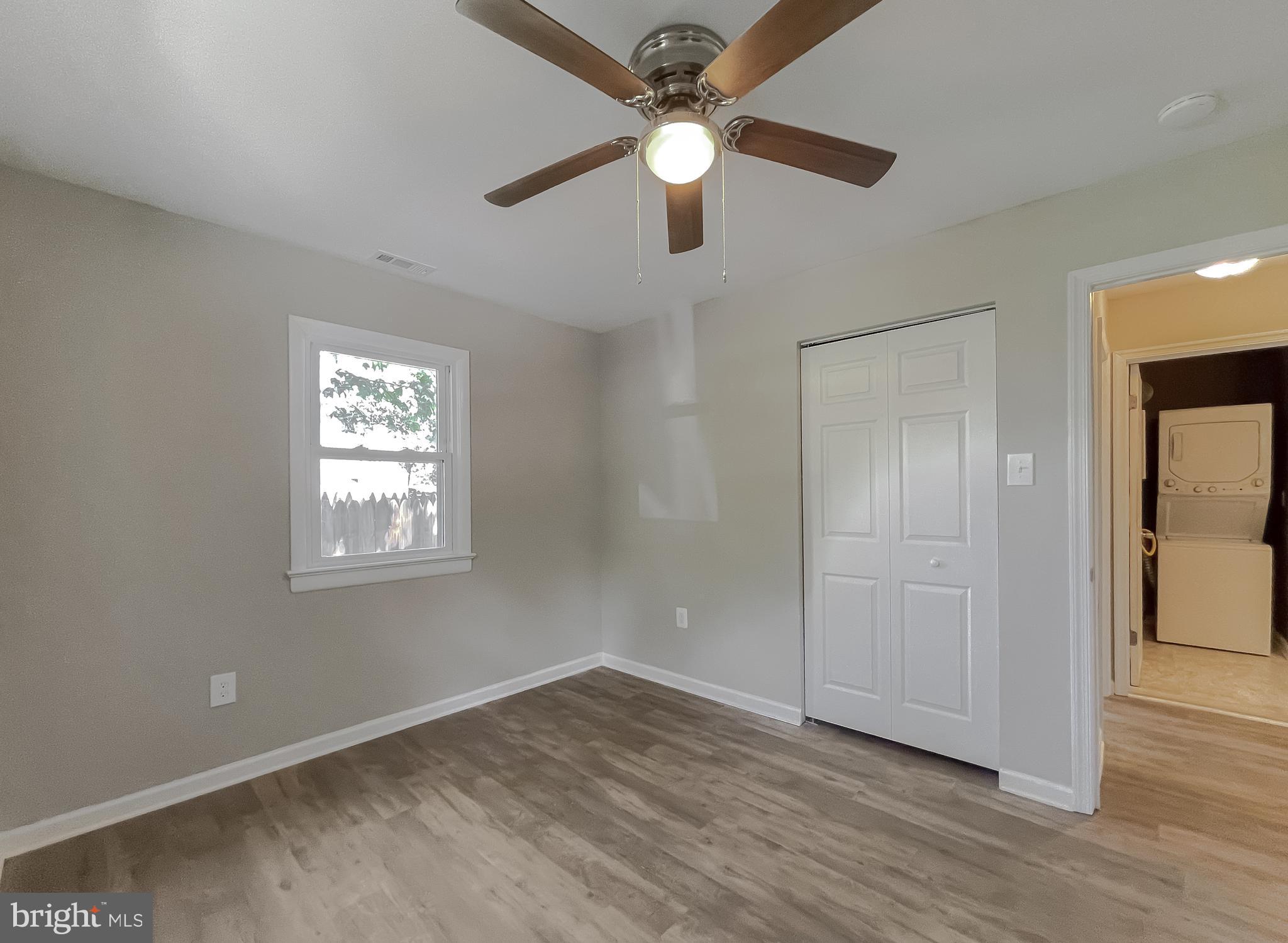 1607 Beech Road St. Leonard, MD 20685 - Photo 24 of 33 an empty room with wooden floor fan and windows