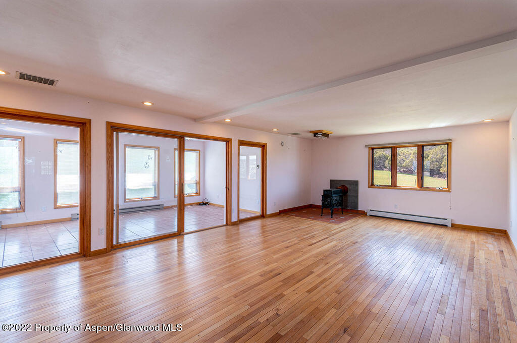 47417 KE Road Mesa, CO 81643 - Photo 3 of 40 an empty room with wooden floor and windows
