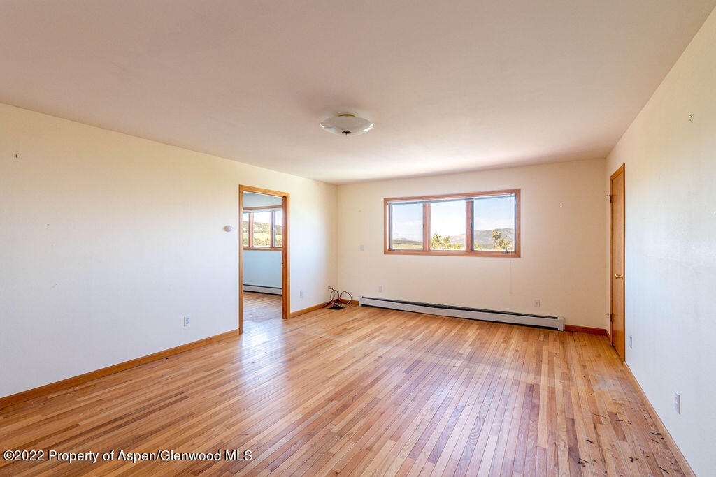 47417 KE Road Mesa, CO 81643 - Photo 9 of 40 an empty room with wooden floor and windows