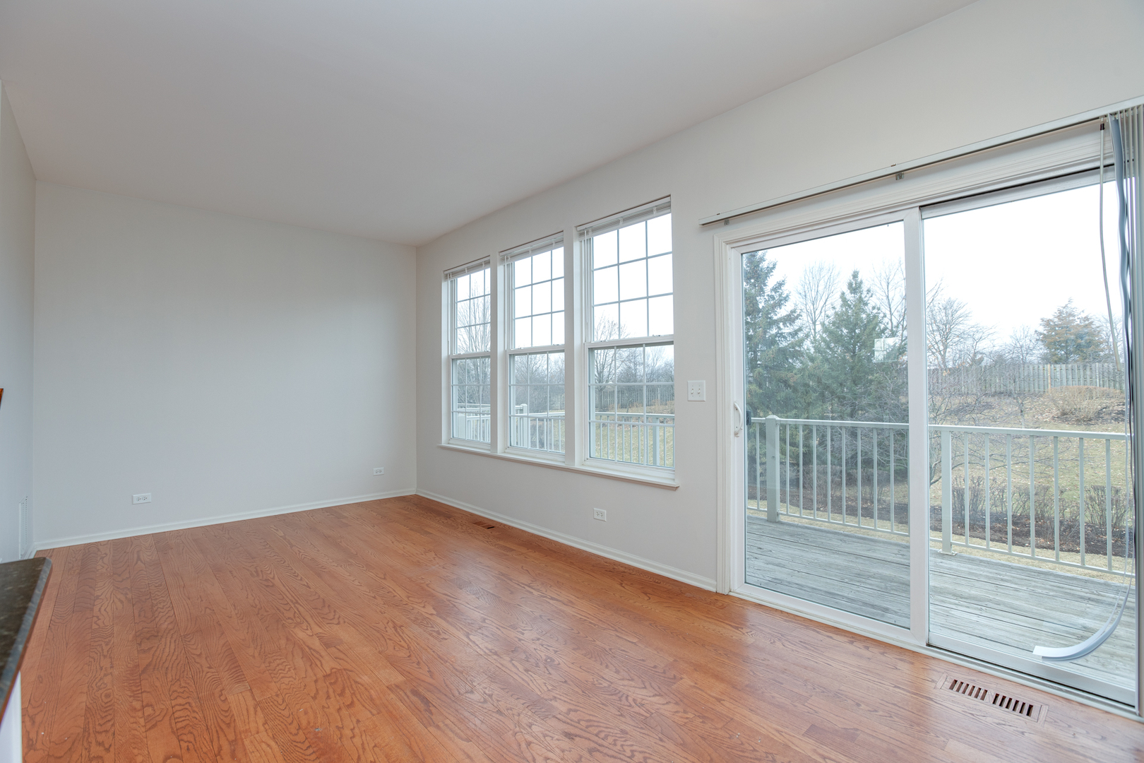 720 Thornbury Road Bartlett, IL 60103 - Photo 4 of 24 a view of an empty room with wooden floor and a window