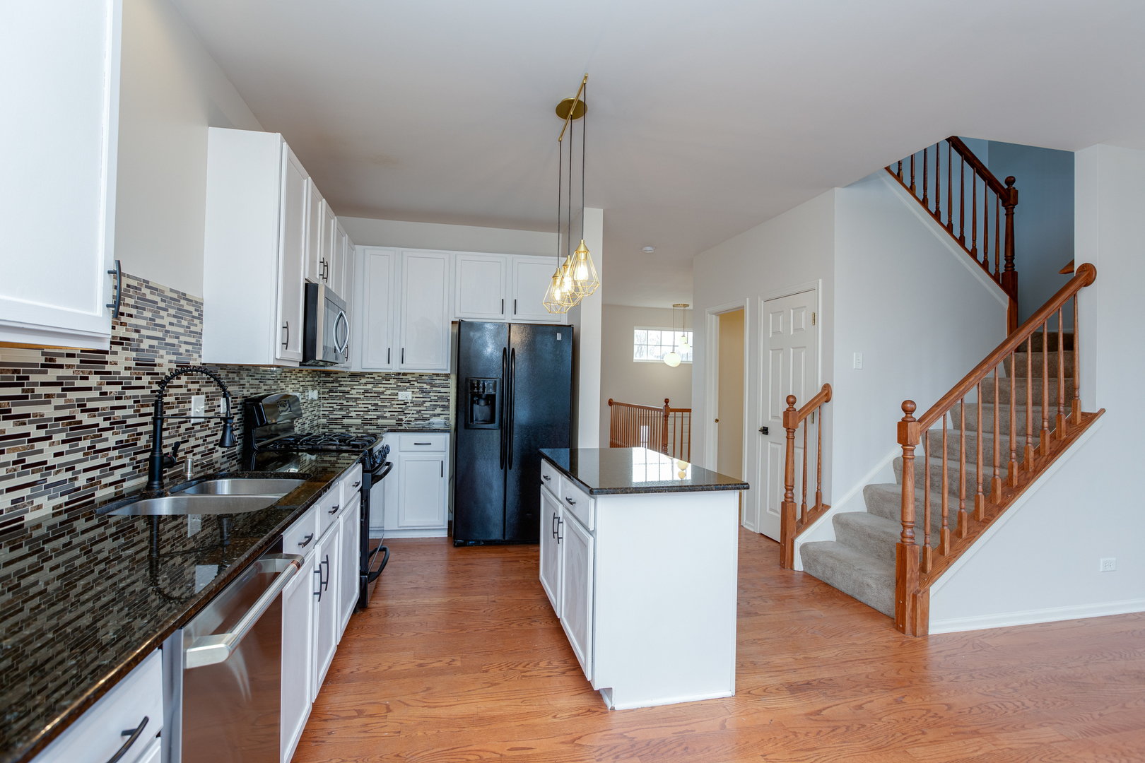 720 Thornbury Road Bartlett, IL 60103 - Photo 6 of 24 a kitchen with a sink a refrigerator and a stove