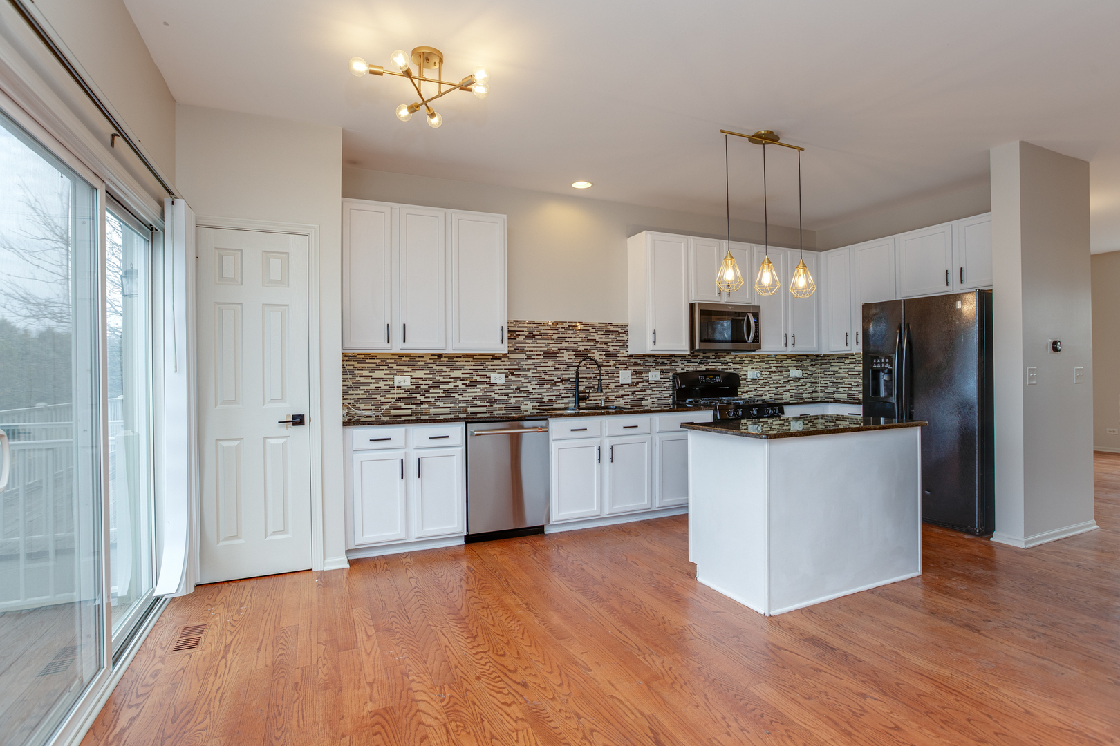 720 Thornbury Road Bartlett, IL 60103 - Photo 7 of 24 a kitchen with stainless steel appliances granite countertop a refrigerator a sink dishwasher a stove and white cabinets with wooden floor