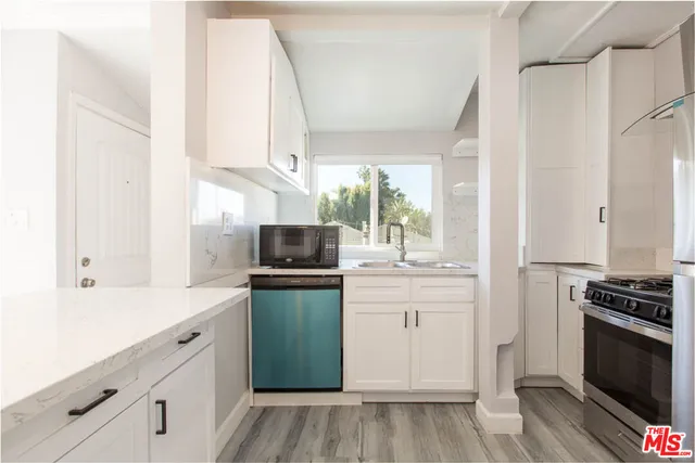 a kitchen with granite countertop a refrigerator stove and sink