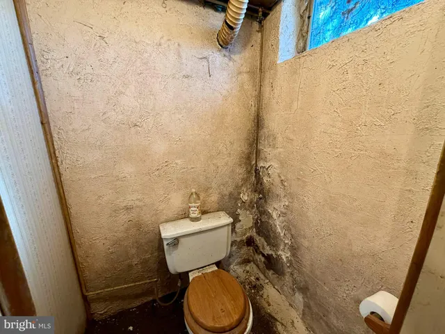 a bathroom with a toilet and a shower curtain