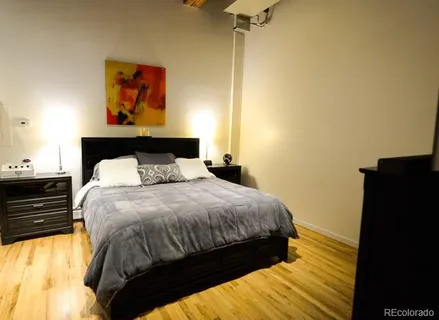 a bedroom with a bed and a painting on the wall