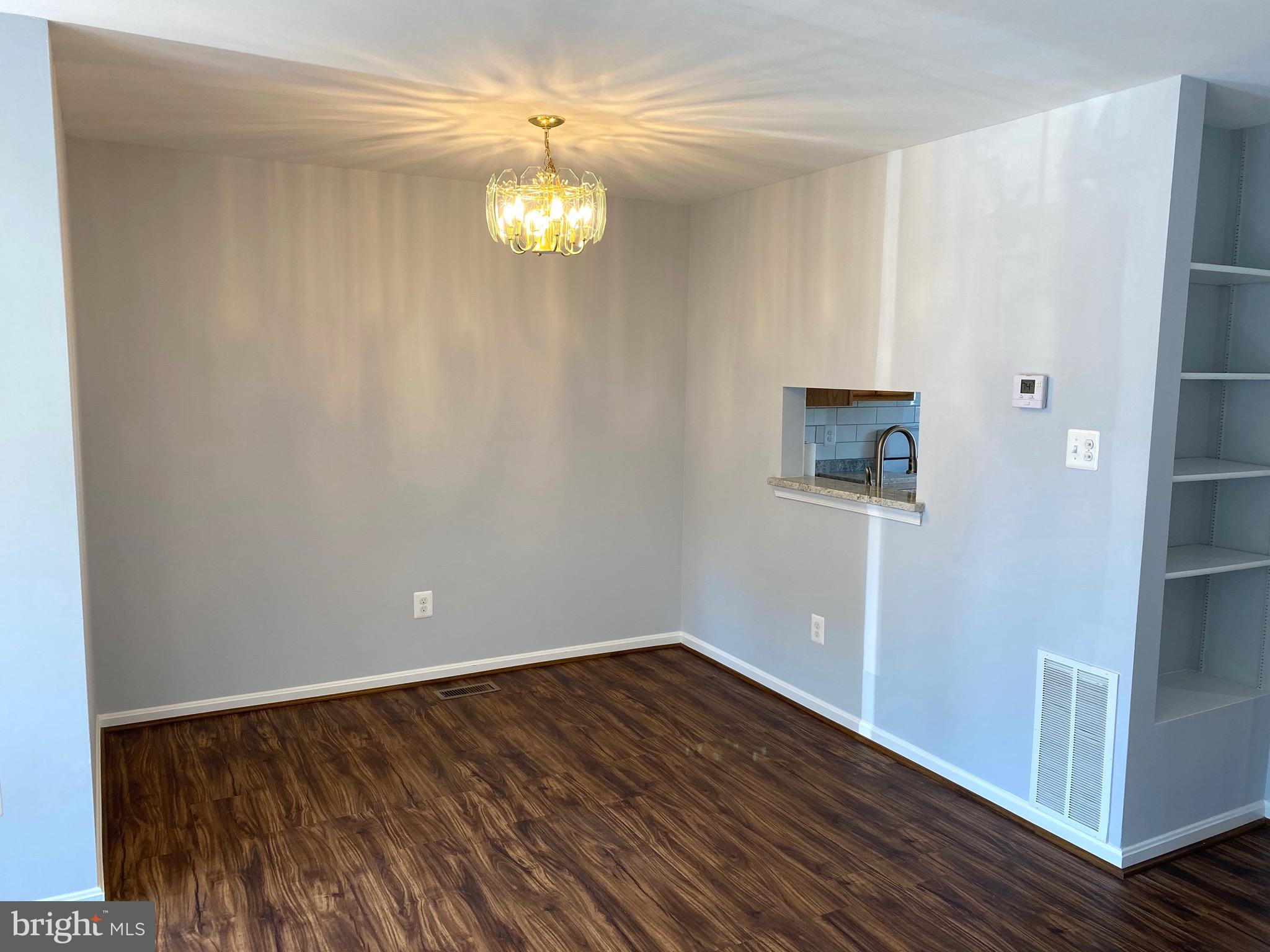 8081 Barcarole Court Springfield, VA 22153 - Photo 12 of 64 a view of an empty room with wooden floor and a window