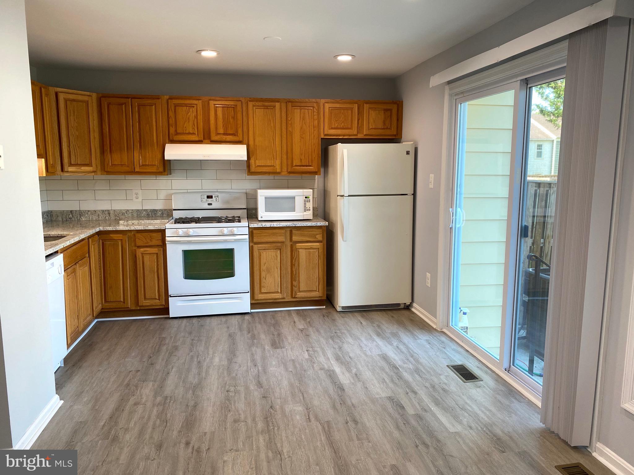 8081 Barcarole Court Springfield, VA 22153 - Photo 19 of 64 a kitchen with a refrigerator sink and wooden cabinets