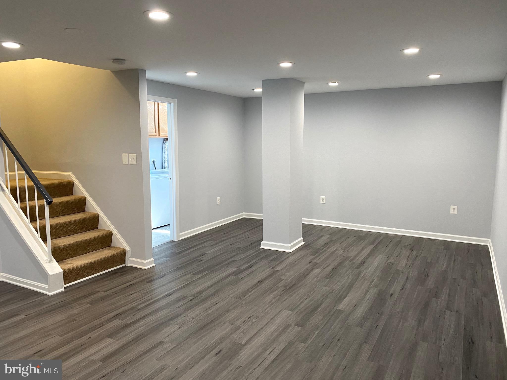 8081 Barcarole Court Springfield, VA 22153 - Photo 49 of 64 a view of an empty room with wooden floor and stairs