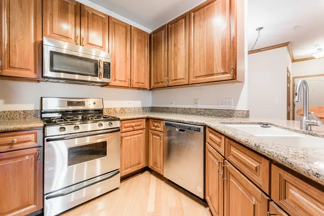 a kitchen with granite countertop stainless steel appliances a stove a sink and a microwave