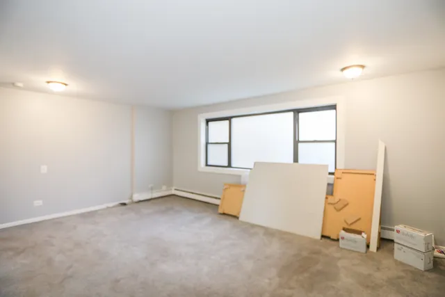 an empty room with a window and a couch