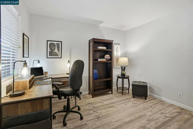 a view of a workspace with furniture and a window