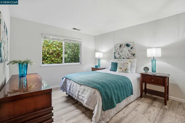 a bedroom with a bed table and a window