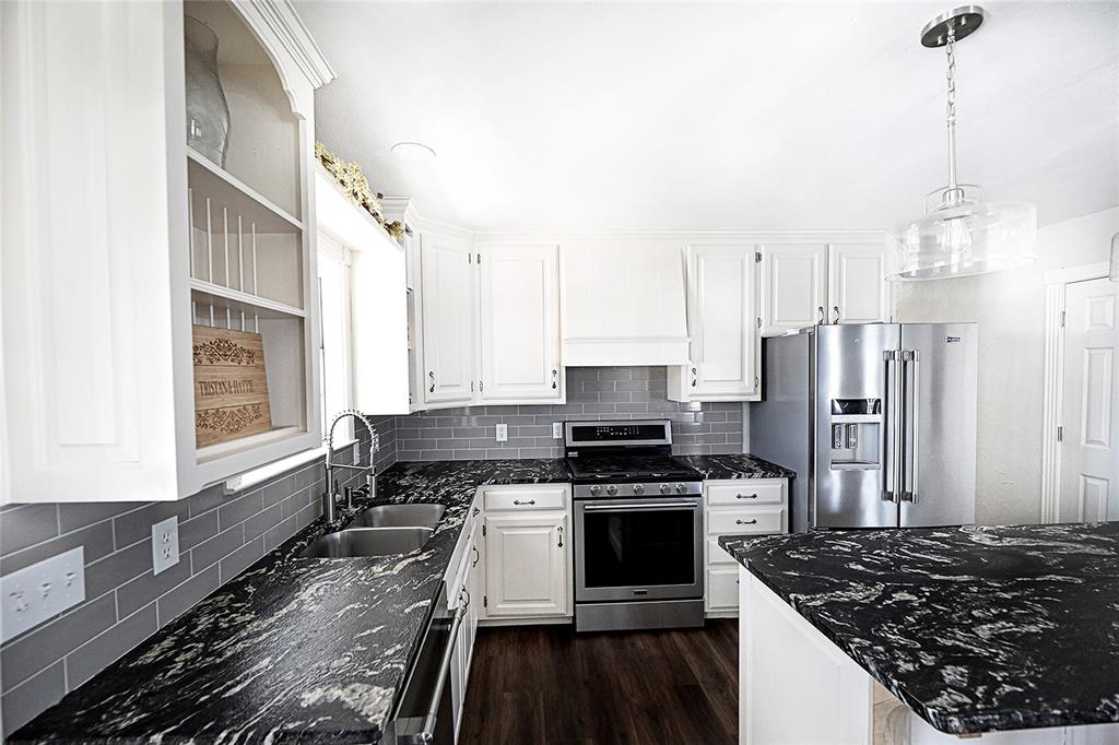 1364 Winn Road Bowie, TX 76230 - Photo 12 of 38 a kitchen with stainless steel appliances granite countertop a stove and a refrigerator