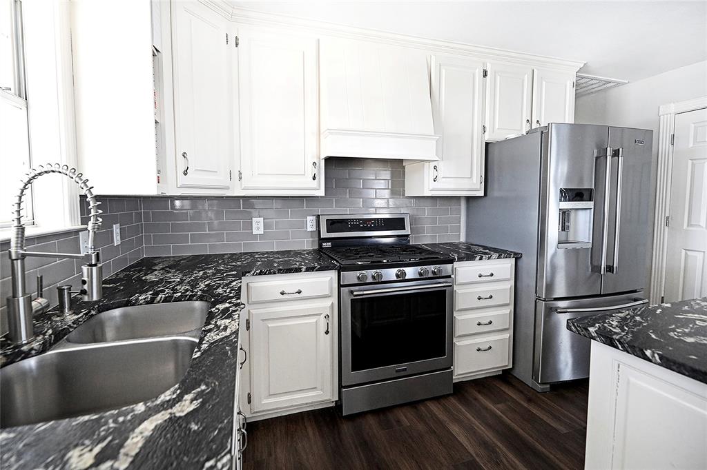 1364 Winn Road Bowie, TX 76230 - Photo 13 of 38 a kitchen with granite countertop a sink stove and refrigerator