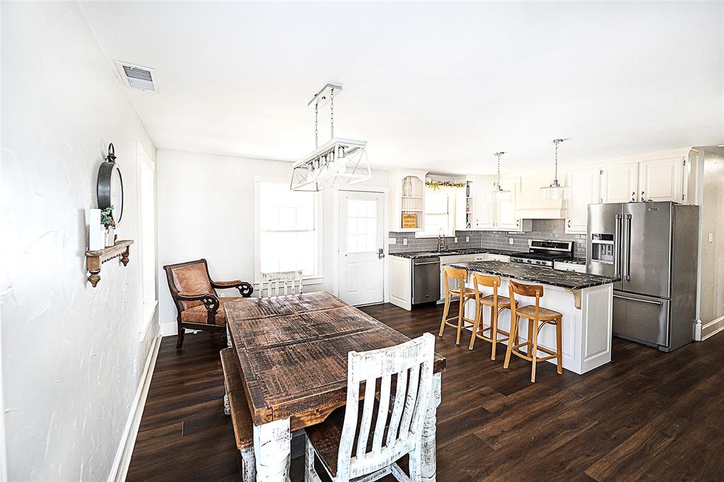 1364 Winn Road Bowie, TX 76230 - Photo 17 of 38 a kitchen with stainless steel appliances kitchen island granite countertop a dining table chairs and granite counter tops