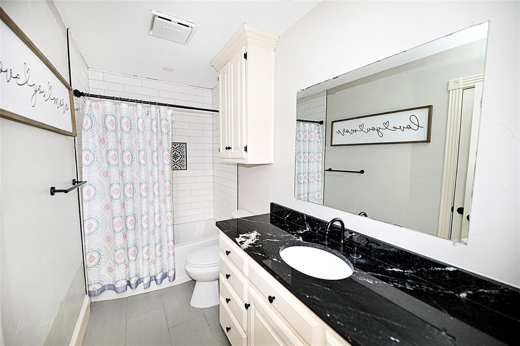 1364 Winn Road Bowie, TX 76230 - Photo 22 of 38 a bathroom with a double vanity sink toilet and shower