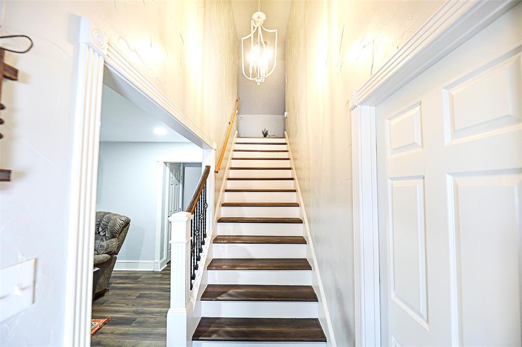 1364 Winn Road Bowie, TX 76230 - Photo 7 of 38 a view of a hallway with wooden floor and staircase