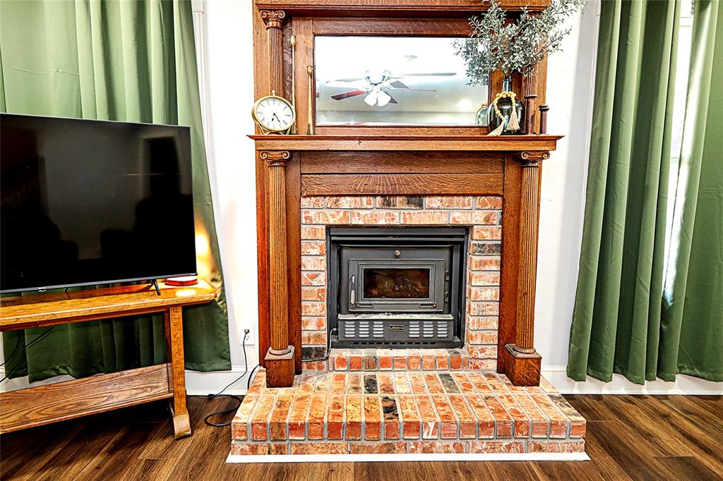 1364 Winn Road Bowie, TX 76230 - Photo 10 of 38 a living room with a fireplace a flat screen tv and a fireplace