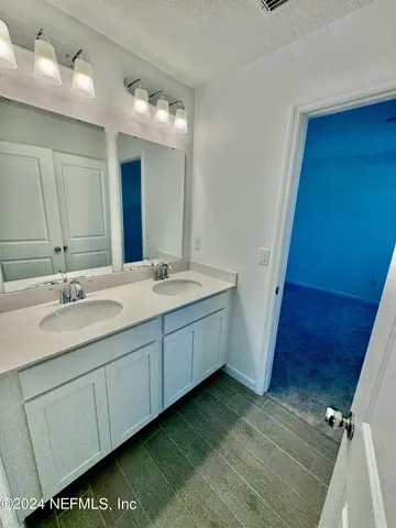 a bathroom with a double vanity sink and a mirror