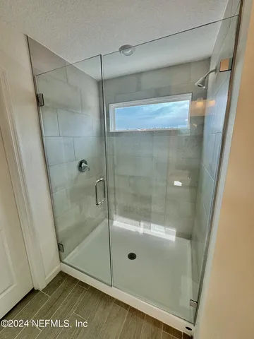 a bathroom with a glass shower door