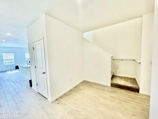 a view of a hallway view with wooden floor and staircase