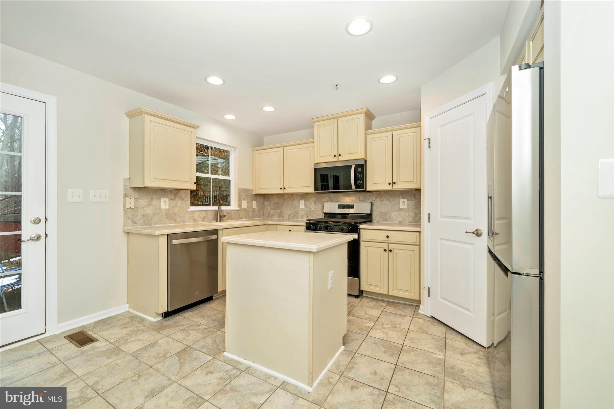 7014 Linden Avenue Elkridge, MD 21075 - Photo 16 of 42 a kitchen with a sink a refrigerator and cabinets