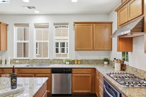 a kitchen with stainless steel appliances granite countertop a sink stove and cabinets