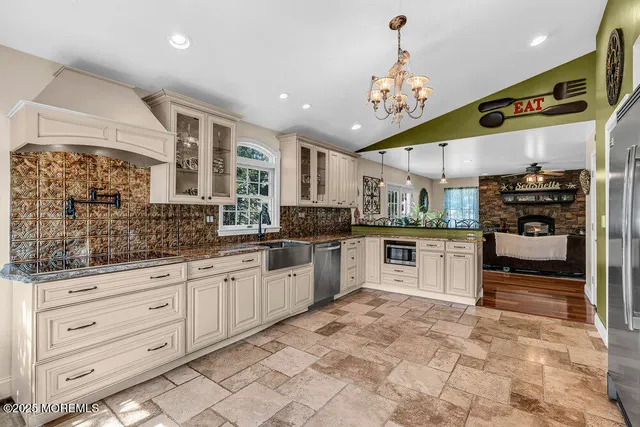 a large kitchen with stainless steel appliances kitchen island granite countertop a sink and cabinets