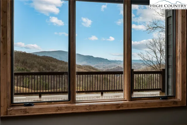 a view of an empty room with glass door and wooden floor
