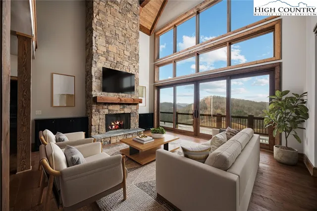 a living room with furniture a fireplace and a floor to ceiling window