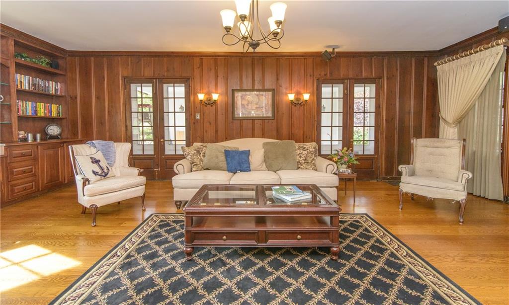 268 Merriman Road Sewickley Heights, PA 15143 - Photo 7 of 25 The Living room is spacious has a TV that slides into the cabinetry and a large stone fire place. Beautiful floors, wood paneling and built in book shelves.