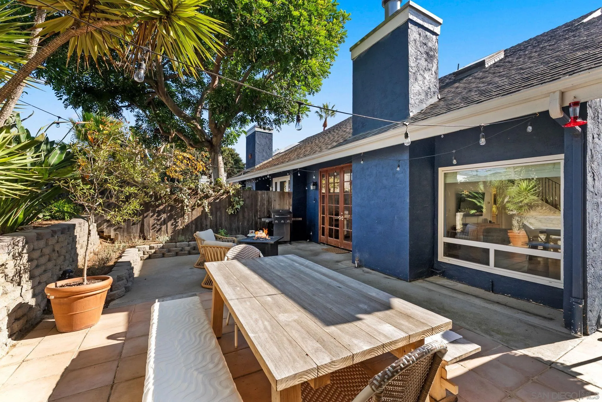 144 Coop Court Encinitas, CA 92024 - Photo 23 of 28 a view of a patio with table and chairs potted plants and large tree