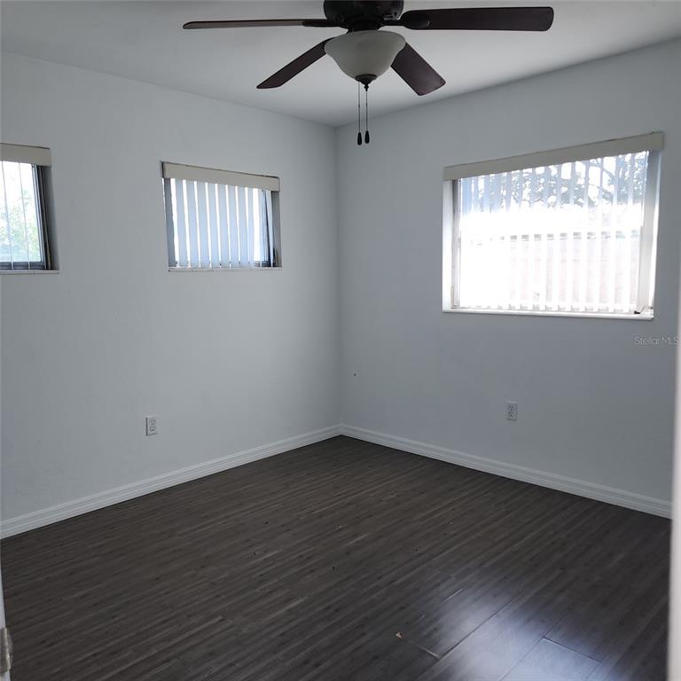 3925 Omega Lane Sarasota, FL 34235 - Photo 18 of 22 a view of an empty room with wooden floor and a window