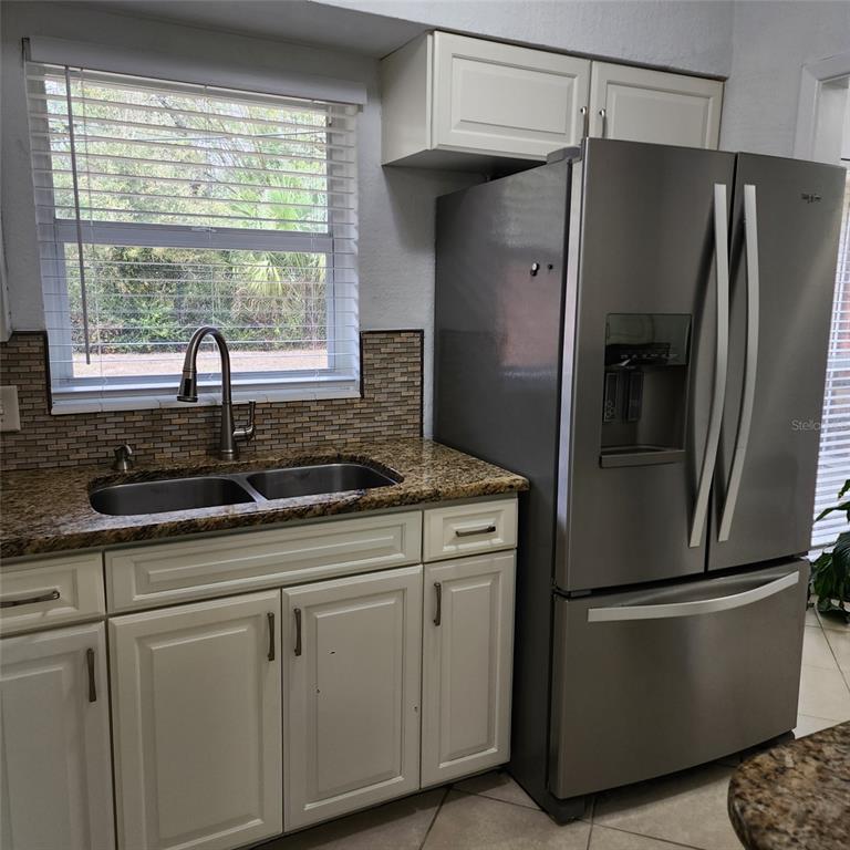 3925 Omega Lane Sarasota, FL 34235 - Photo 3 of 22 a kitchen with stainless steel appliances granite countertop a refrigerator sink and window