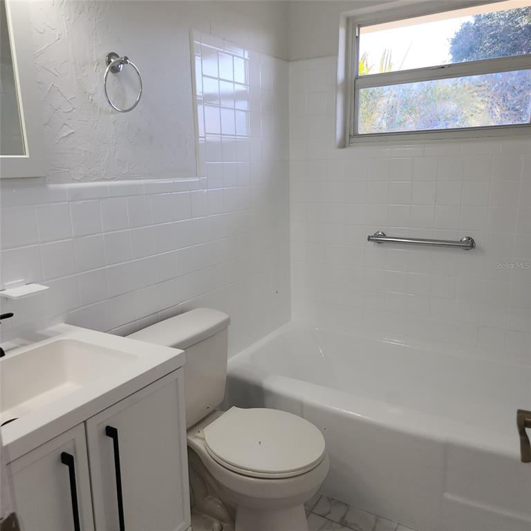 3925 Omega Lane Sarasota, FL 34235 - Photo 5 of 22 a white toilet sitting next to a bath tub