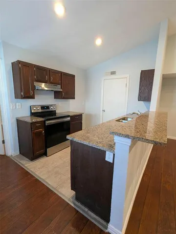 a kitchen with stainless steel appliances granite countertop a stove and a cabinets