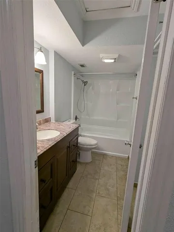 a view of an empty room with wooden floor and a ceiling fan