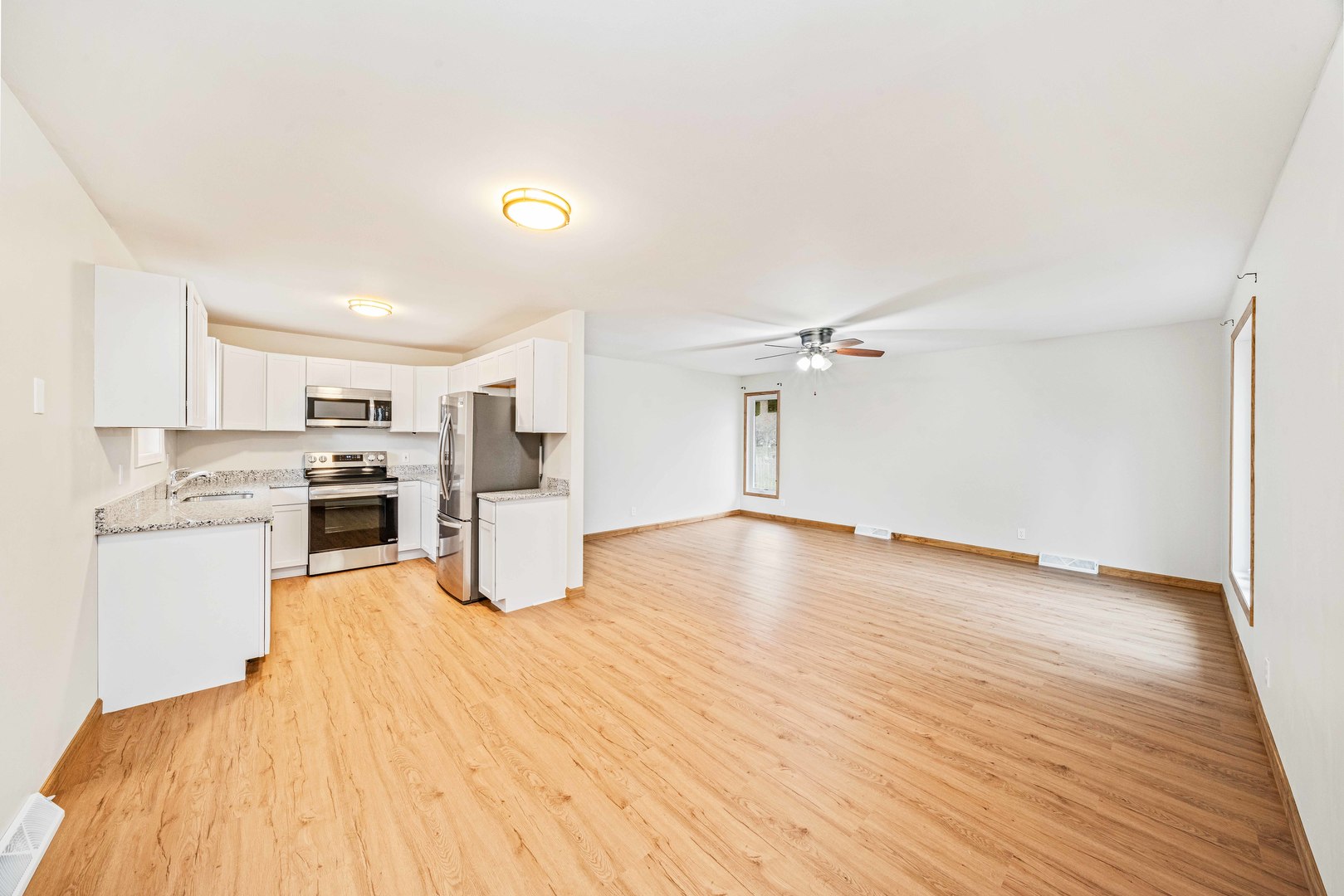 1839 Irene Road Lake Holiday, IL 60548 - Photo 3 of 19 a kitchen with stainless steel appliances granite countertop a refrigerator a stove oven a sink dishwasher and white cabinets with wooden floor