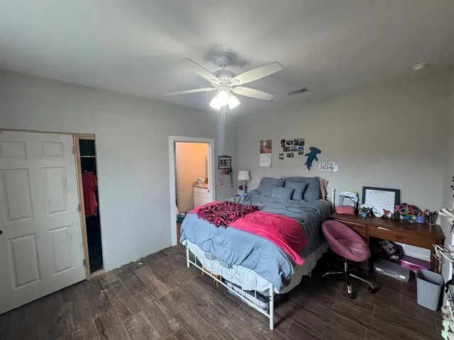 a bedroom with a bed and wooden floor