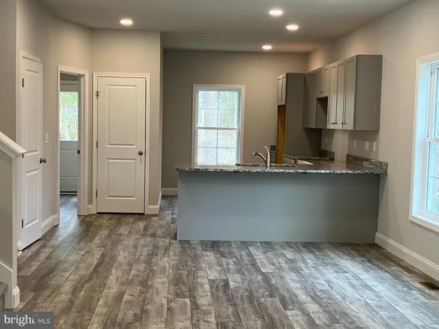 a view of kitchen with granite countertop cabinets and refrigerator