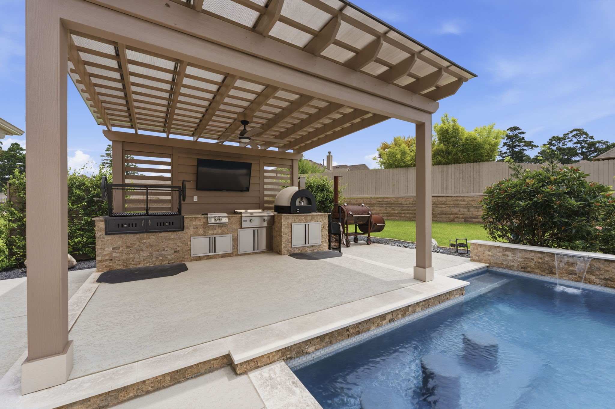 14012 Beartooth Bend Trail Conroe, TX 77384 - Photo 38 of 50 One of the most distinctive features of this exceptional poolscape is the swim-up bar seating located alongside the outdoor kitchen. Whether enjoying a cold drink or a light lunch, you can remain comfortably in the pool while taking full advantage of this thoughtfully designed outdoor entertaining space.
