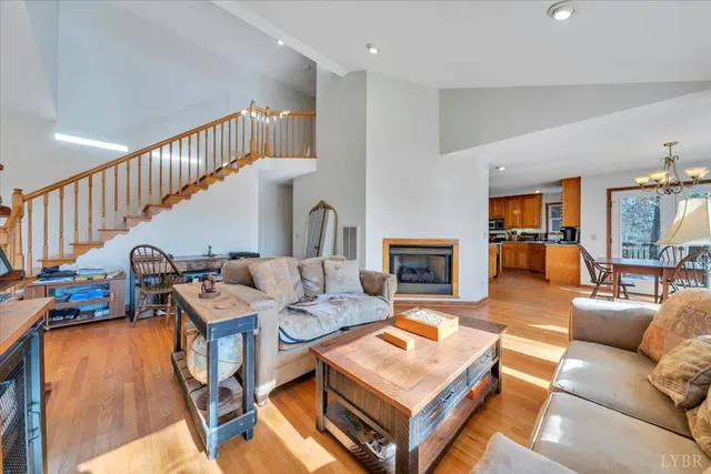 a kitchen with stainless steel appliances granite countertop a stove top oven a refrigerator a sink dishwasher and a dining table with wooden floor