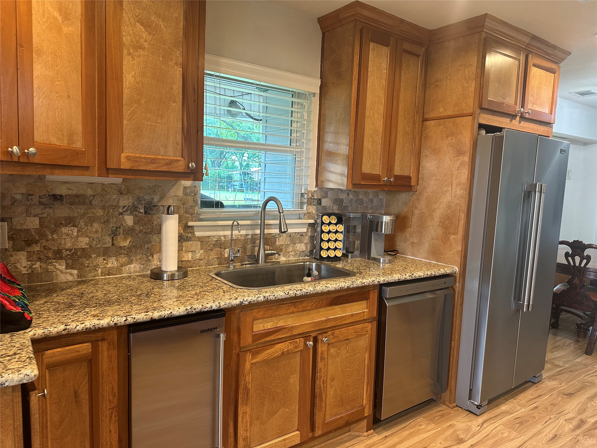 16607 Mueschke Road Cypress, TX 77433 - Photo 23 of 24 a kitchen with stainless steel appliances granite countertop a sink and a refrigerator