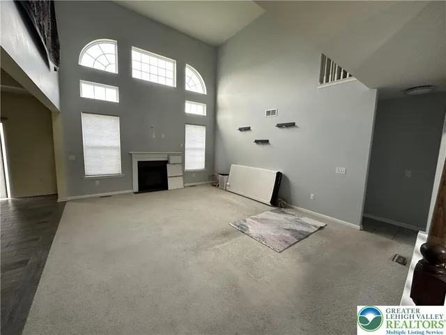 a view of an empty room with a fireplace and a window