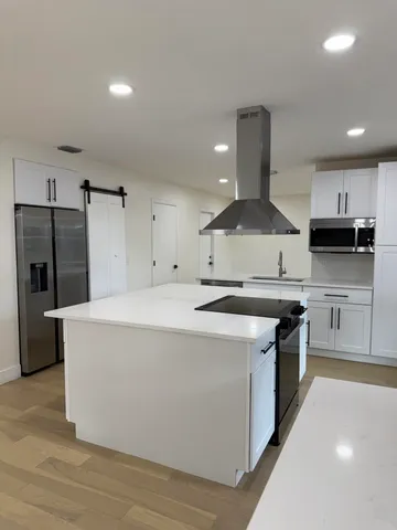 a kitchen with stainless steel appliances a stove a sink and a refrigerator
