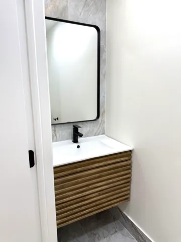 a white toilet sitting next to a white wall