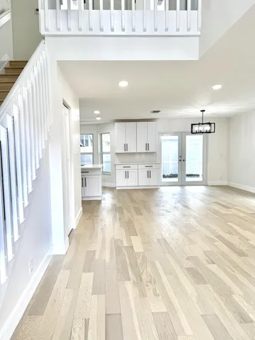a view of kitchen with kitchen island refrigerator cabinets and wooden floor