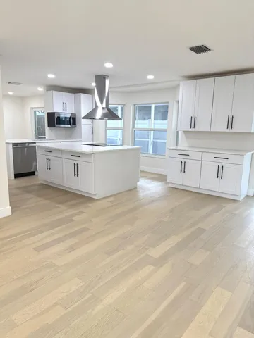 a large kitchen with stainless steel appliances lots of counter top space