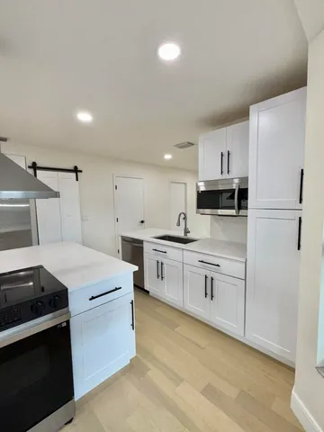 a kitchen with white cabinets and white appliances
